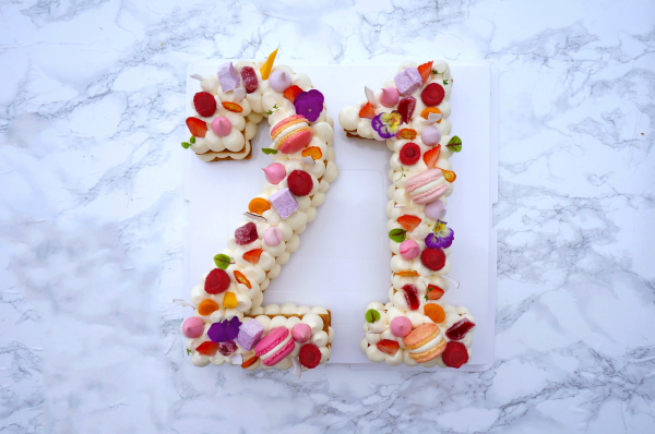 Gateau en forme de chiffre vingt et un. Gateau vu d'en haut, a la vanille, décoré avec des macarons, des fruits frais, des meringues, des guimauves.