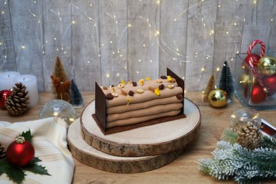 Buche de noel au chocolat dans l'ambiance de noel avec des décorations de fetes